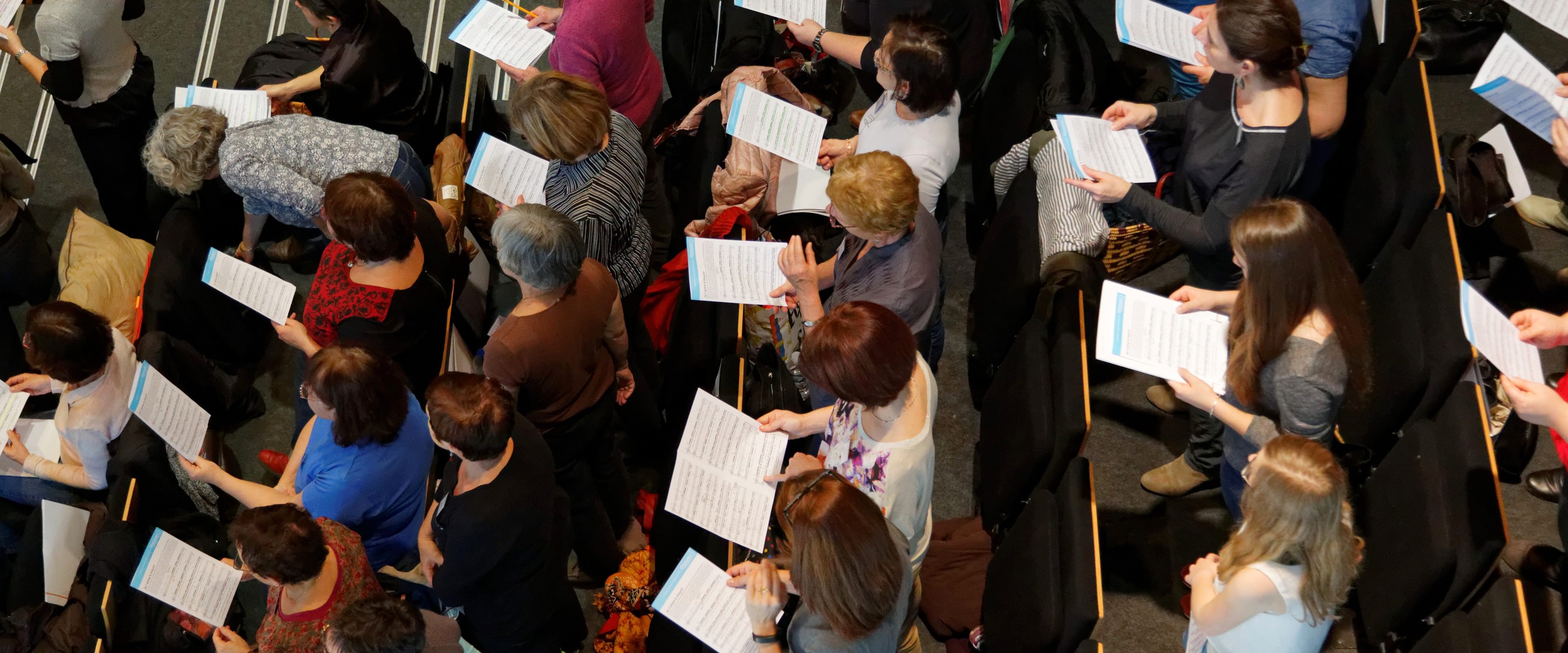 Choristes réunis en répétition, leurs partitions à la main