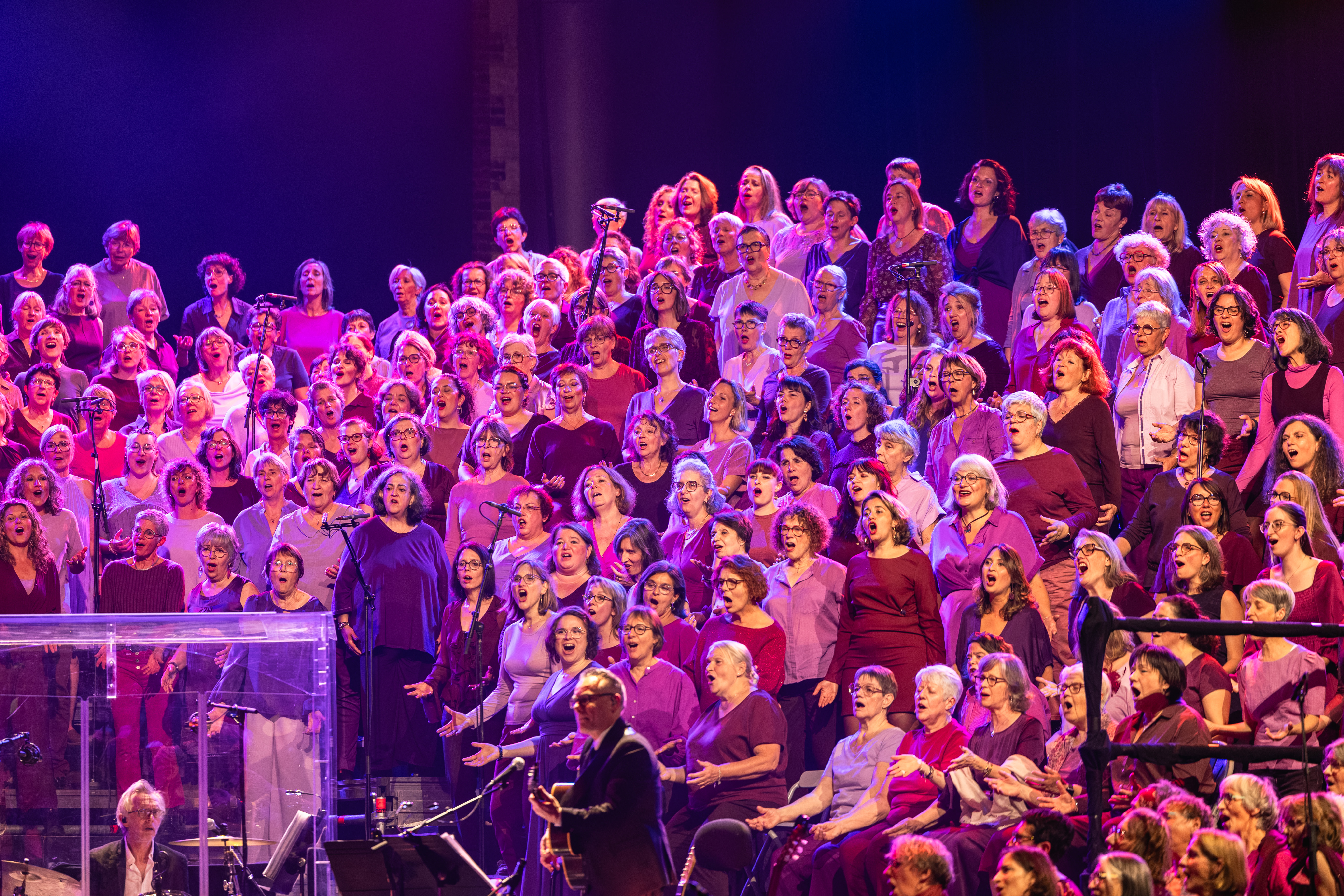 Les choristes interprètent le répertoire sous les lumières violettes
